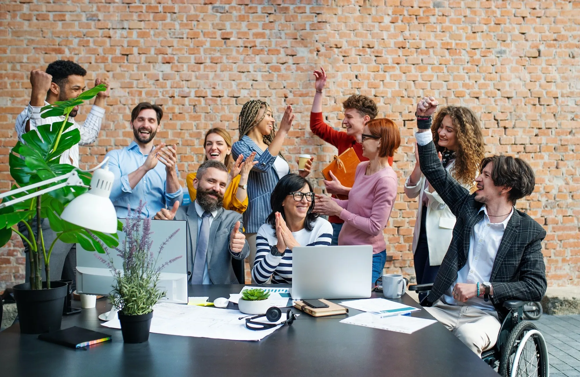 Team che festeggia intorno a un tavolo in ufficio