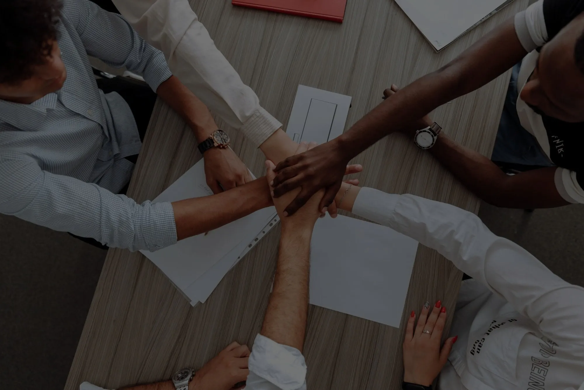 Membri di un team che uniscono le mani su un tavolo riunioni